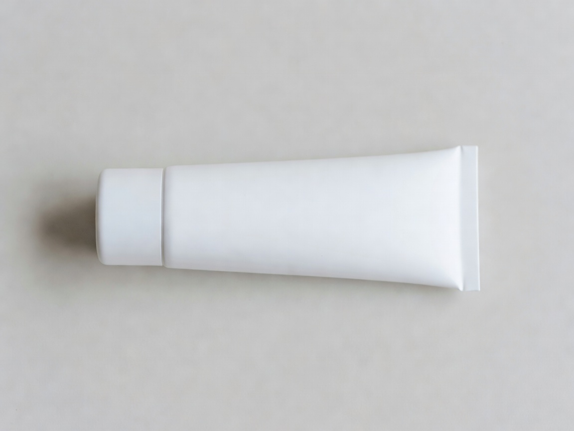Matte white mineral sunscreen tube lying flat on a neutral surface