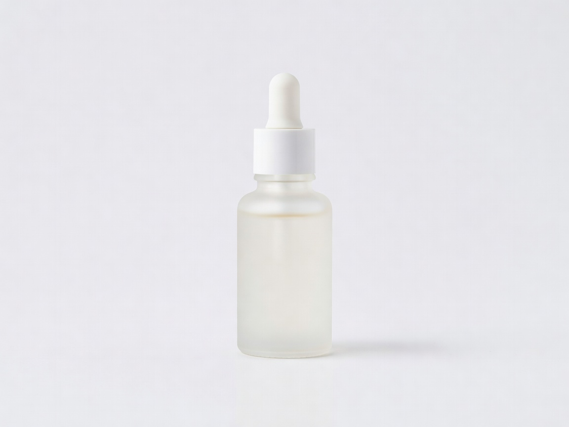 Small frosted dropper bottle of niacinamide serum on a plain white background